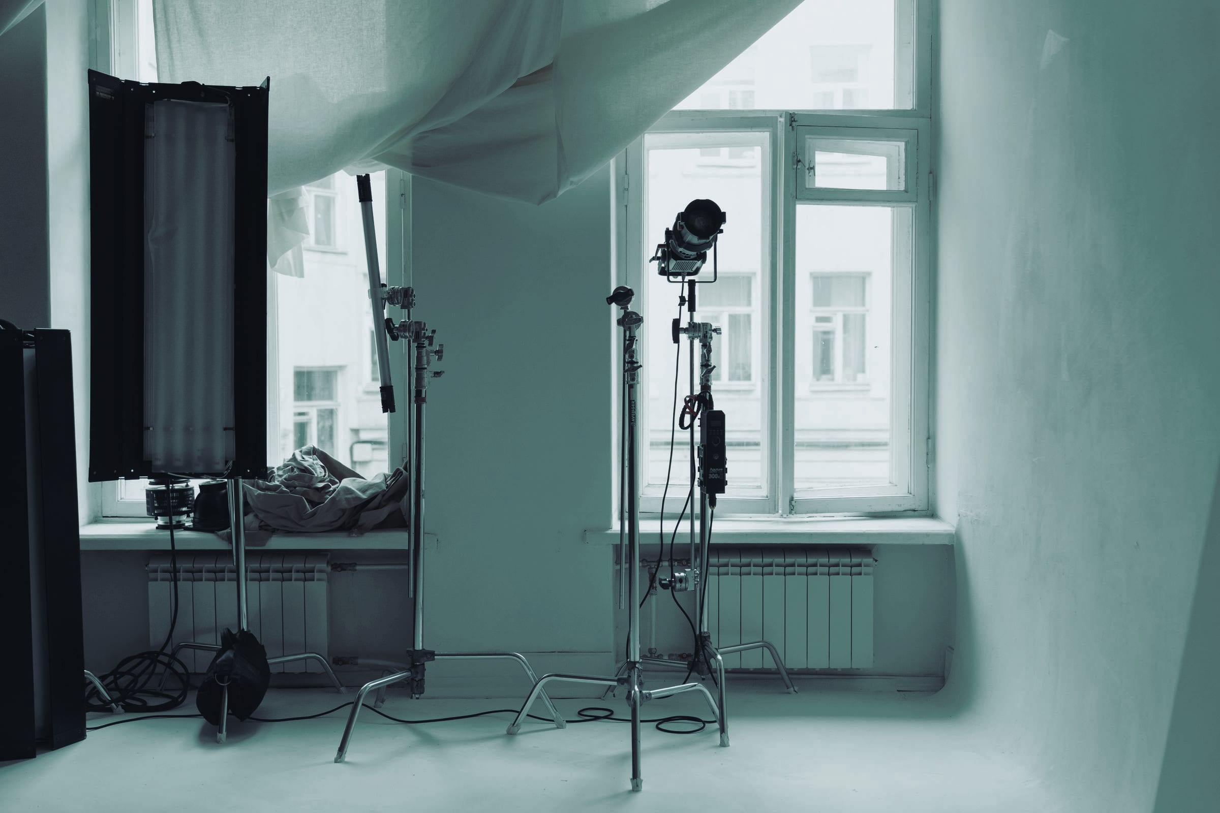 Een studio bij daglicht met lampstatieven, zonder mensen.
