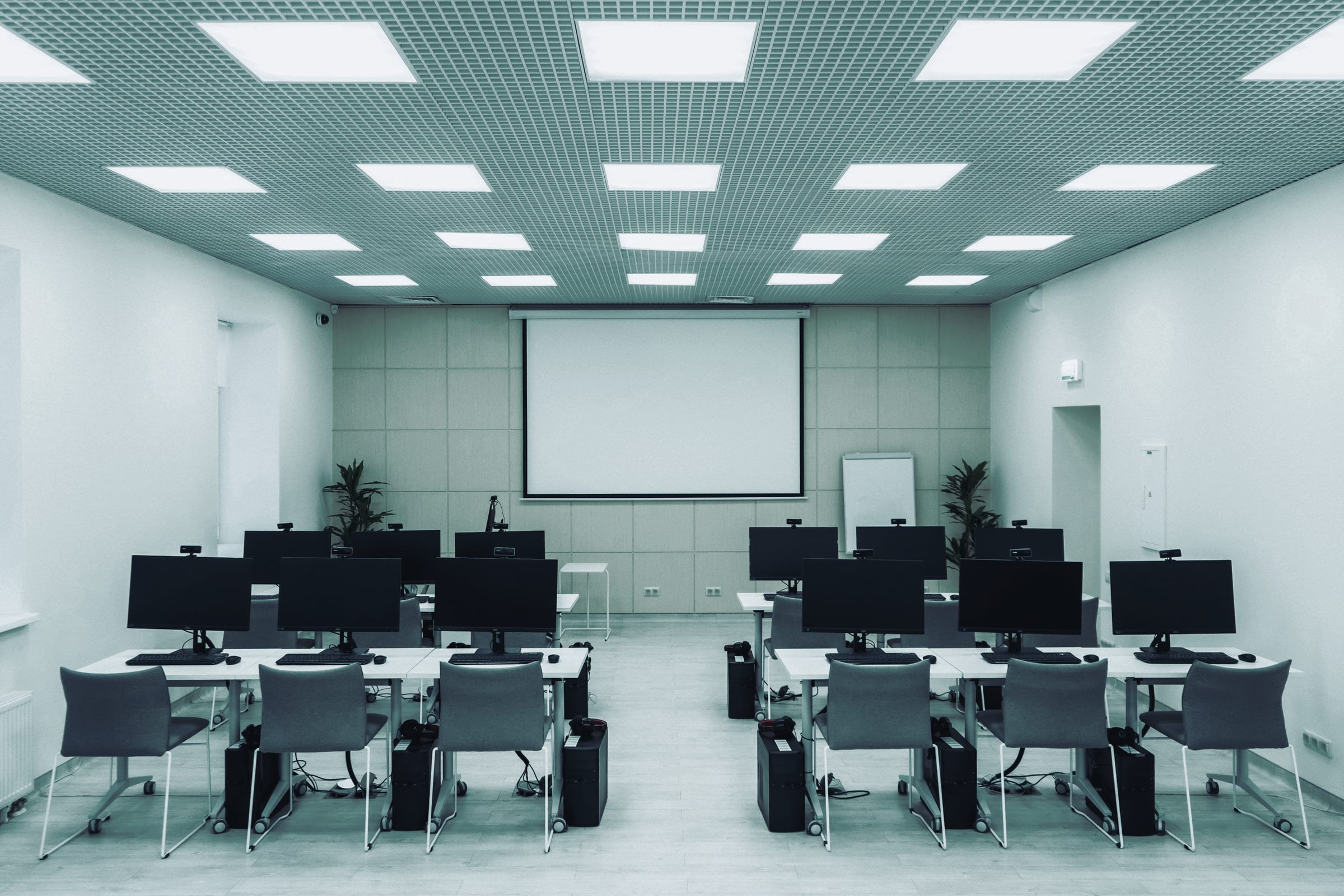 An empty computer classroom with rows of desks.